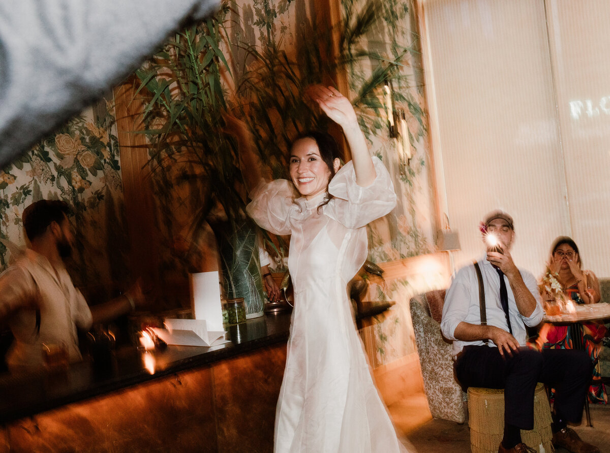 Bride with hands in the air having a great time at The Proper hotel austin wedding reception