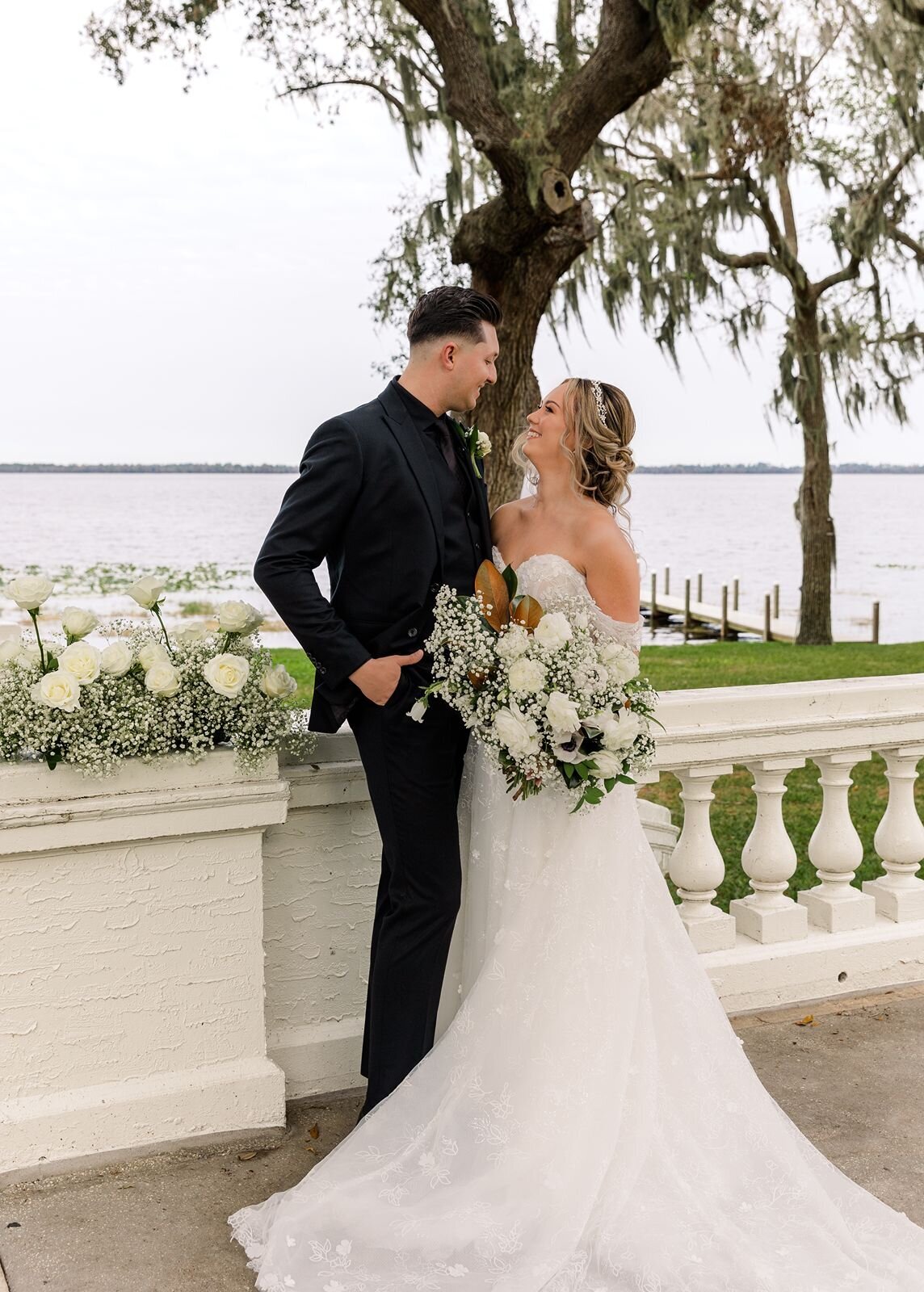 Bride and groom on terrace overlooking lake at Bella Cosa, Lake Wales, Florida