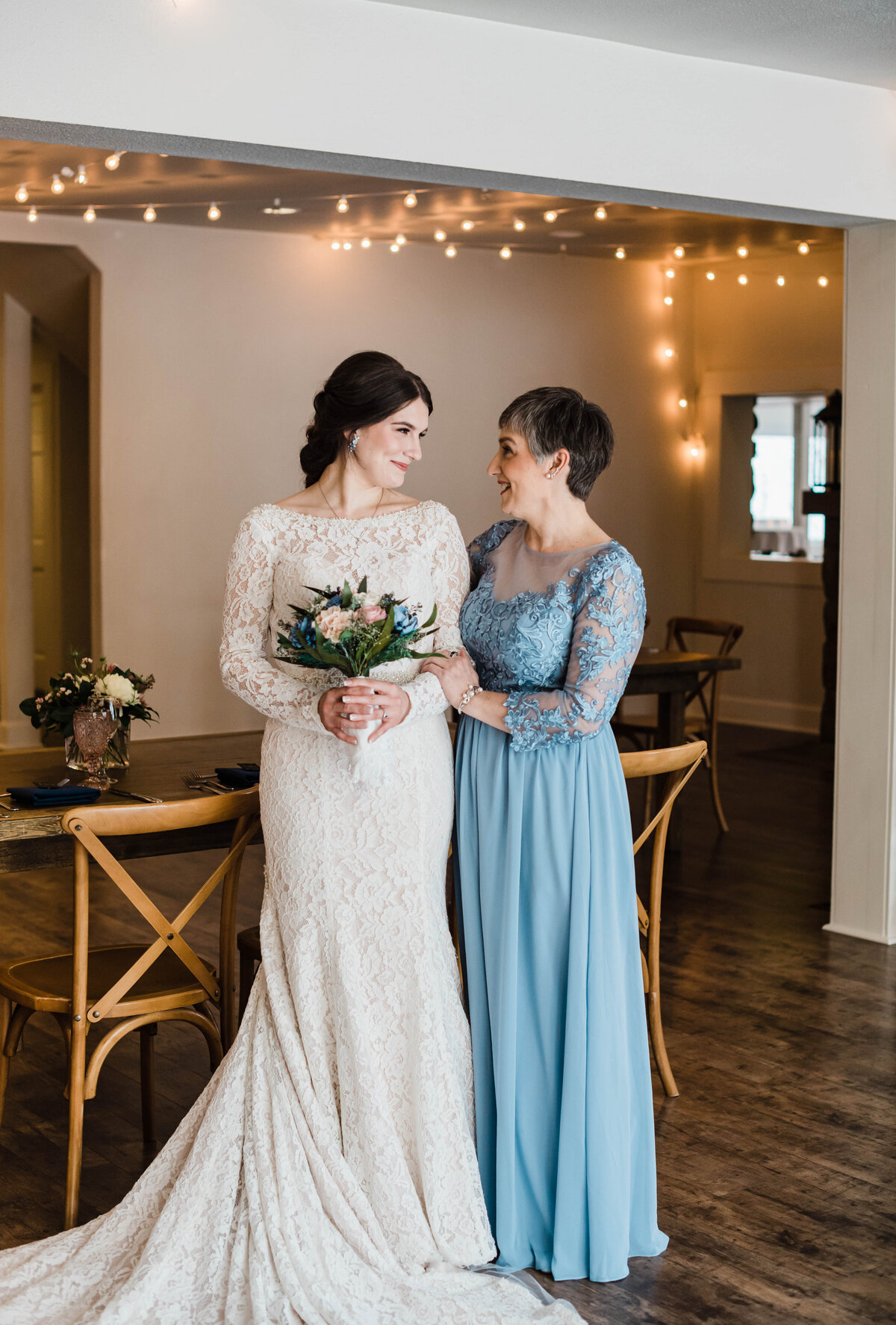 On the bride's wedding day, a mom and daughter share a sweet glance as they smile at each other for denver wedding photographer