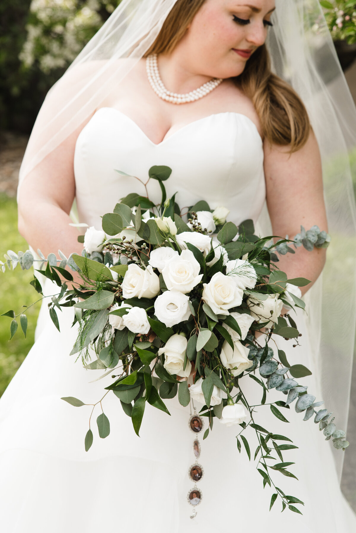 closeup of beautiful bride holding bouquet of white roses