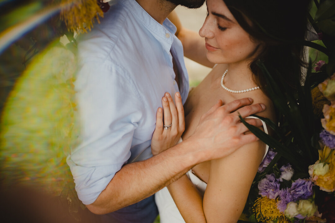 A couple in a romantic pose with colourful flowers taken on the island of Maui