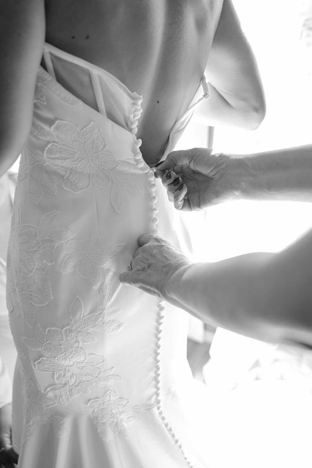 Fine art image of bride stepping into her gown with glowing natural light at a San Antonio luxury venue