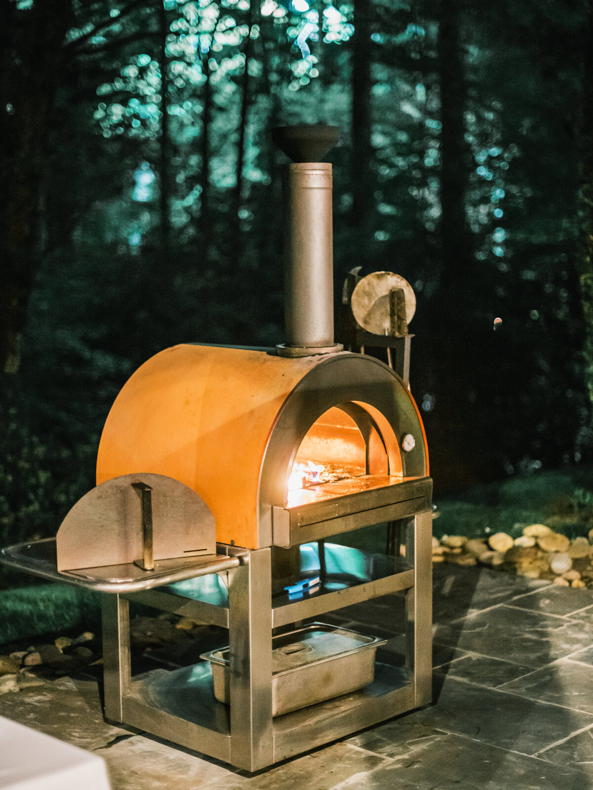 Outdoor wood-fired pizza oven being used during a wedding reception at Old Edwards Inn in Highlands, North Carolina.