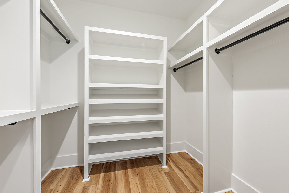 master closet with built in shelving and matte black accents
