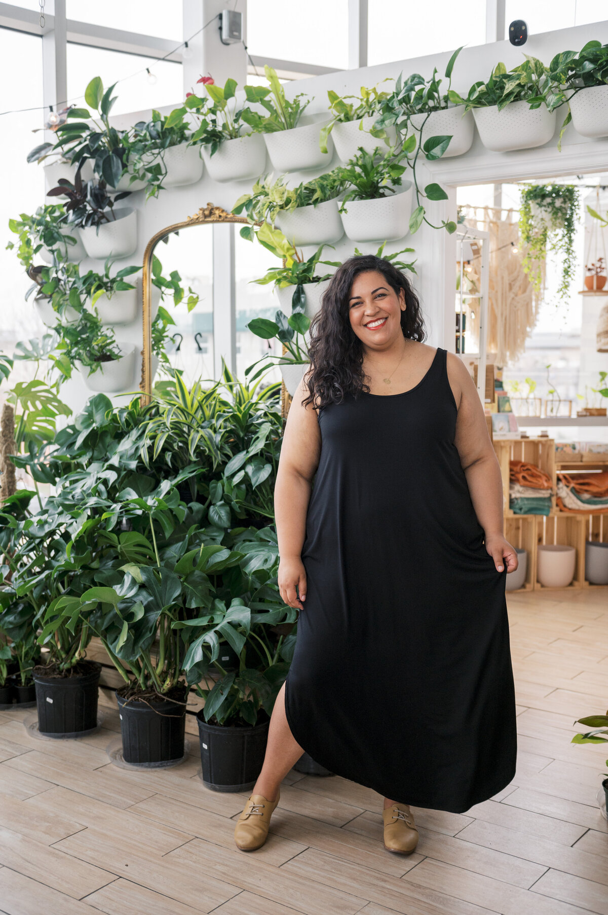 Woman in black maxi tank dress smiling in a plant store
