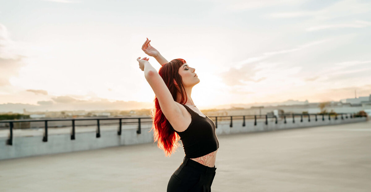 Desiree, Colorado Based Photographer Posing in the Sun with Bright Red Hair