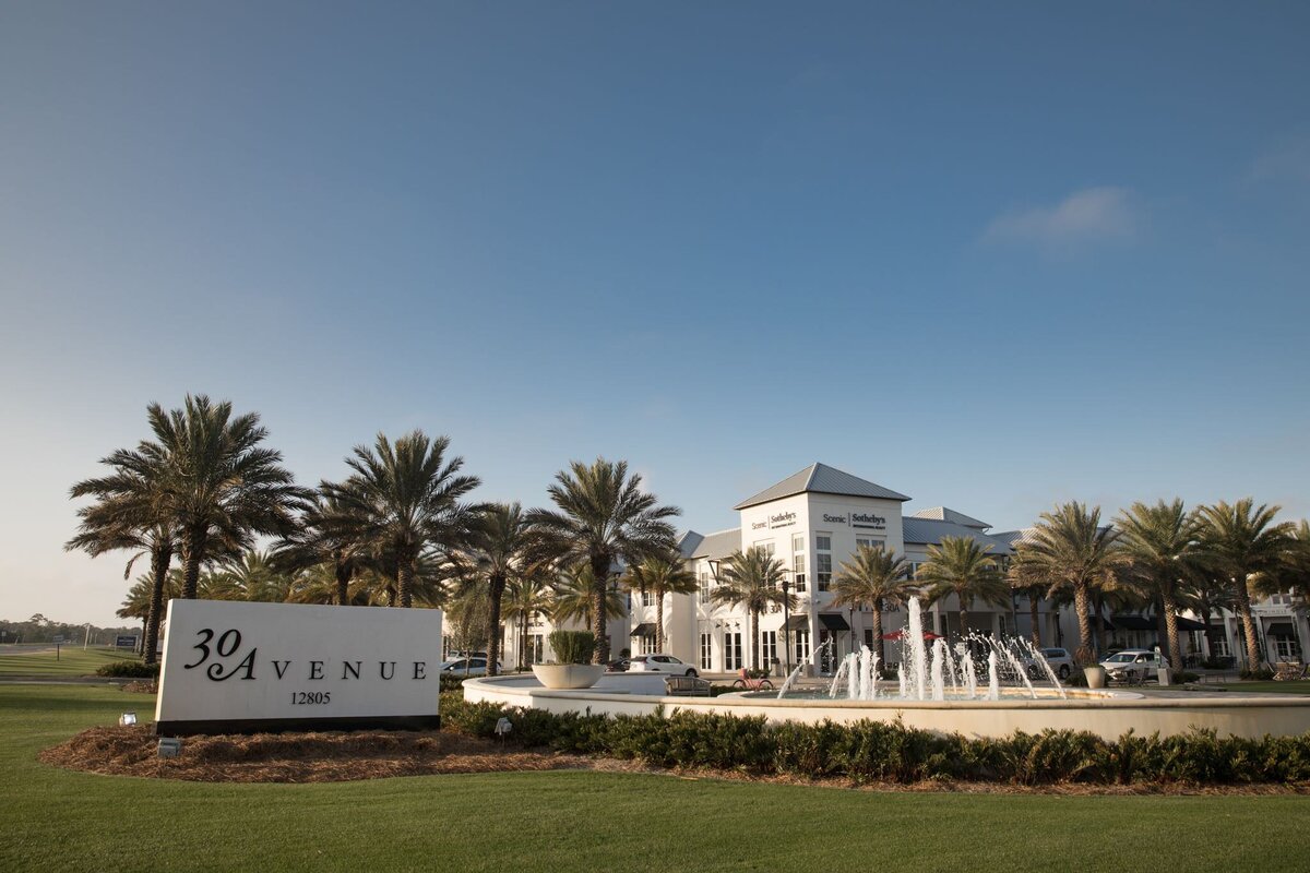 A sign for 30 Avenue with a fountain next to it