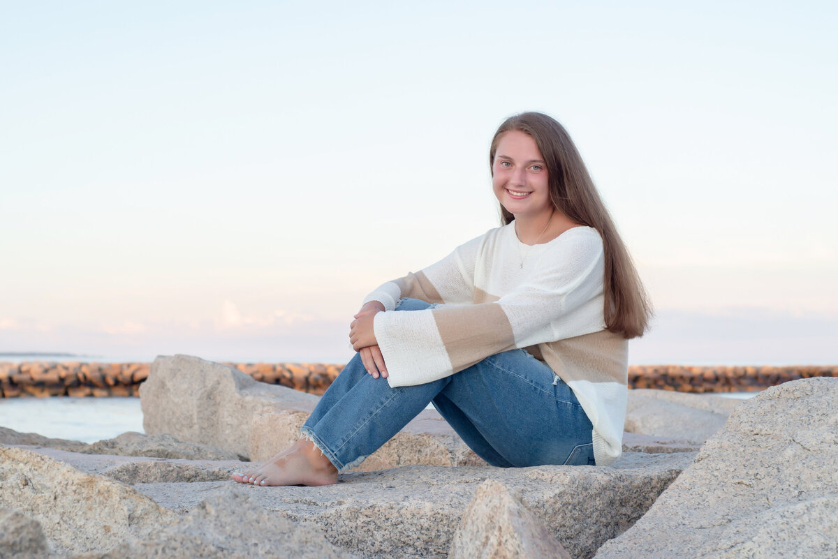 High School Senior girl sitting on wells beach jetty