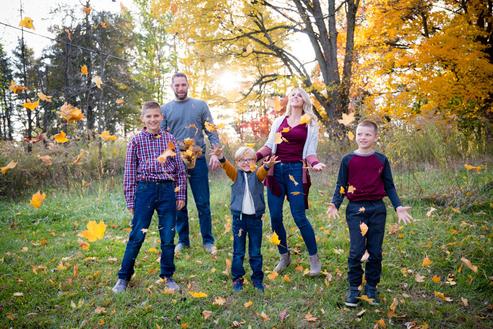Family of 5 throwing leaves in the air