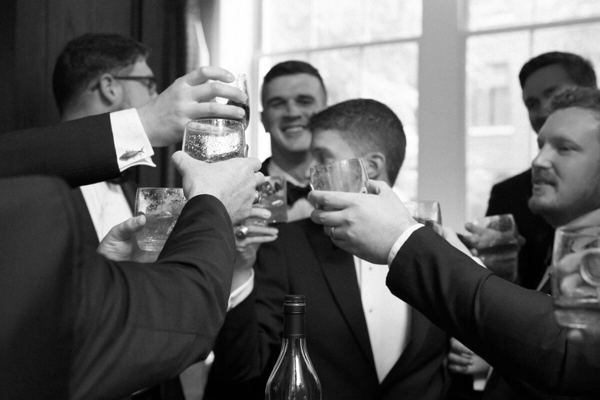 John Marshall Hotel Richmond | black and white image of groom and groomsmen toasting their glasses