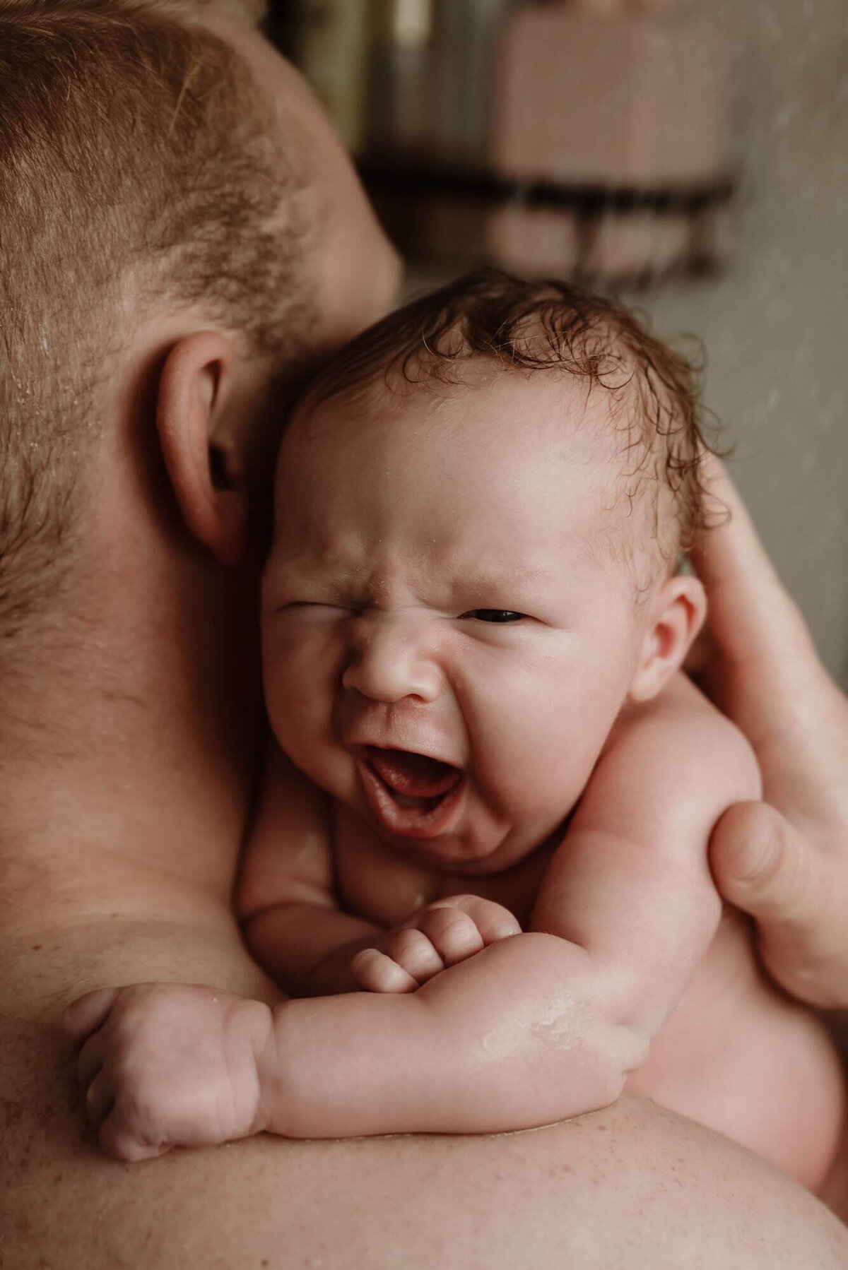 gapende baby in douche met vader tijdens newbornshoot Eline Hemelt Photography