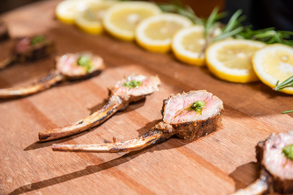 A wooden cutting board with meat and lemon slices on it