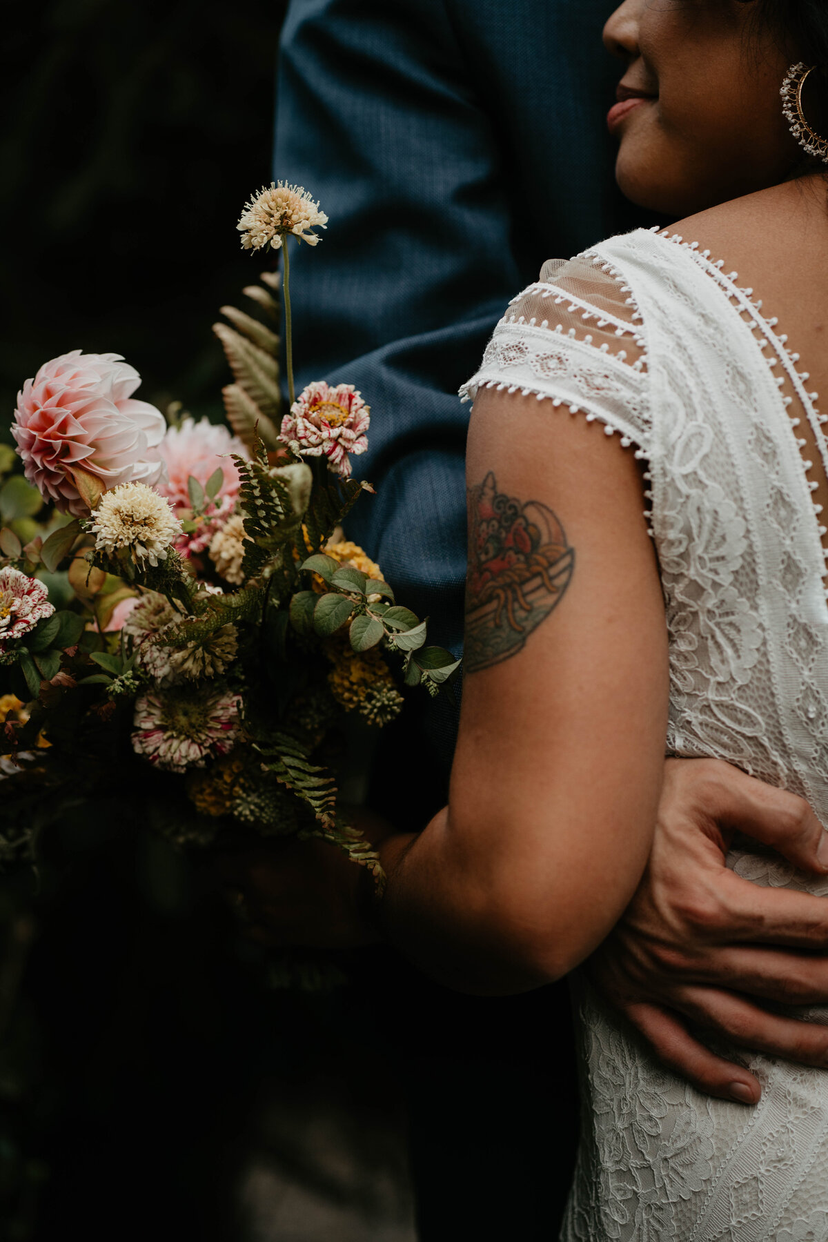 Close up photo of groom holding bride with flowers after Blockhouse PDX wedding