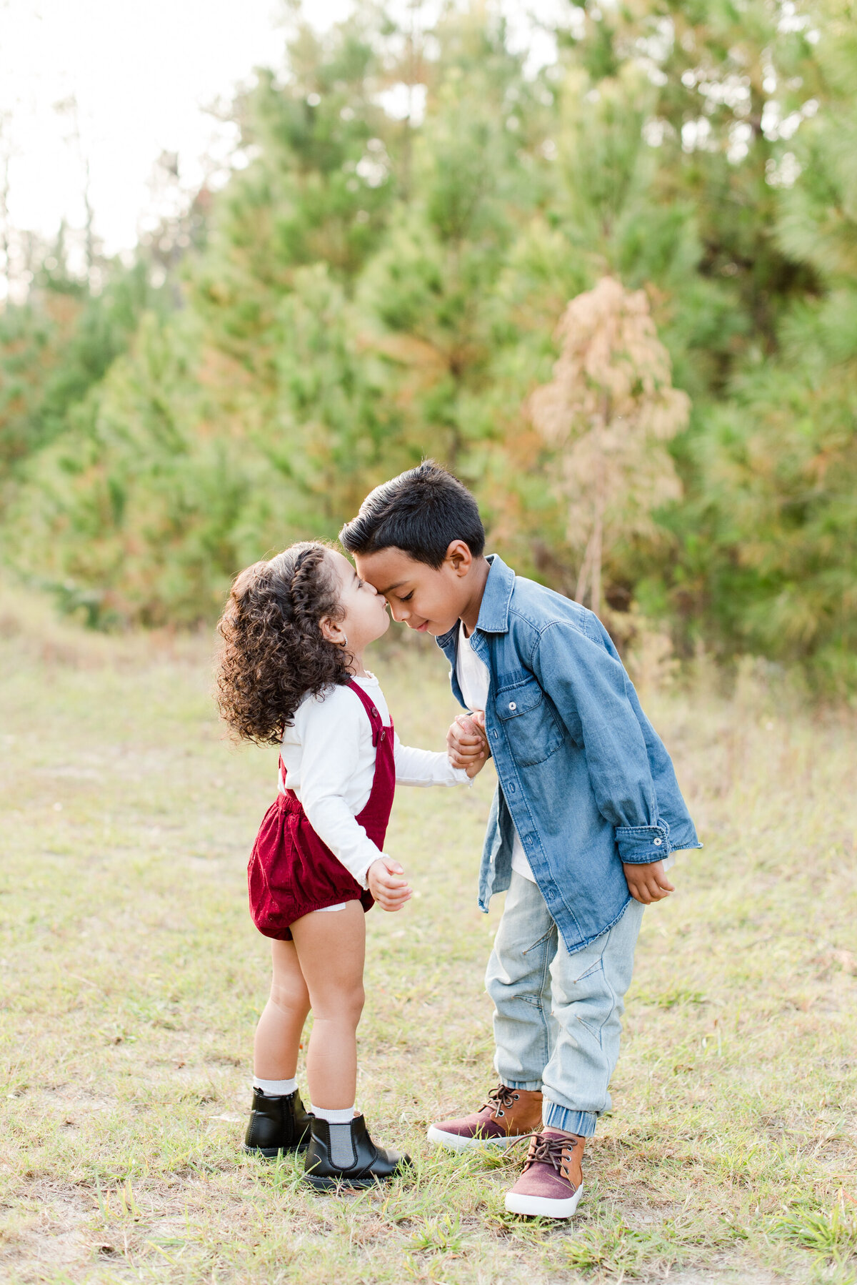 siblings boy and girl  kissing burgindy  romper and denim jacket