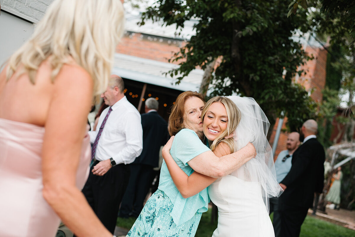 Candid moment of a grandmother hugging the groom at a Denver wedding reception.