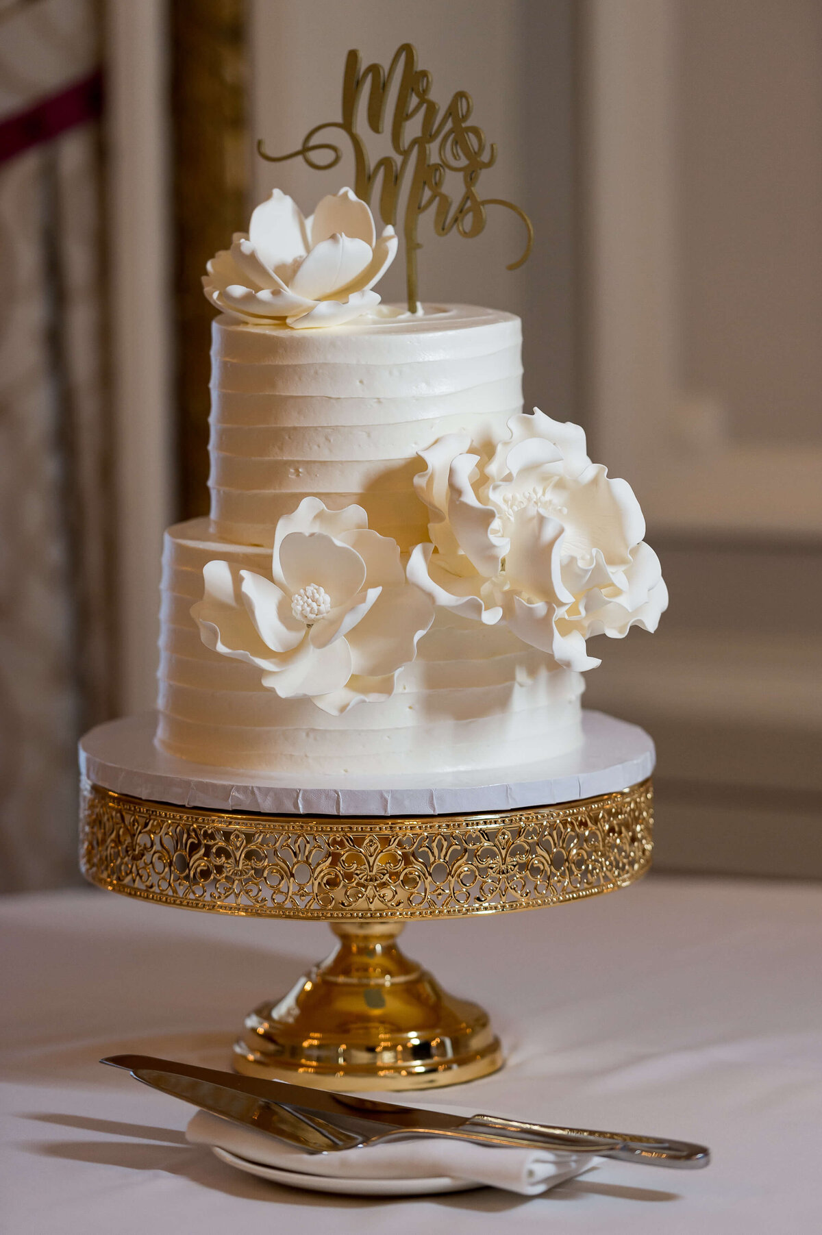 a very elegant white and gold wedding cake made by Thimble Cakes.  Captured by Ottawa wedding photographer JEMMAN Photography