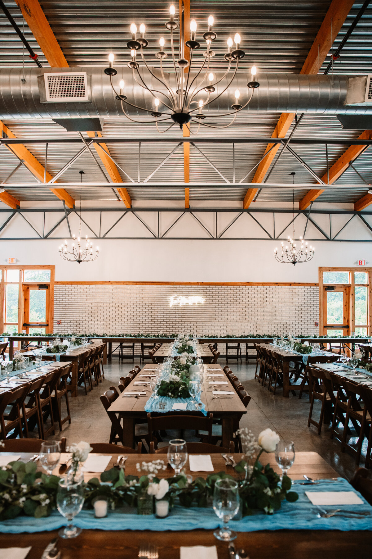 A wedding reception with blue linens seat up at the Aspen Sky Winery and Distillery