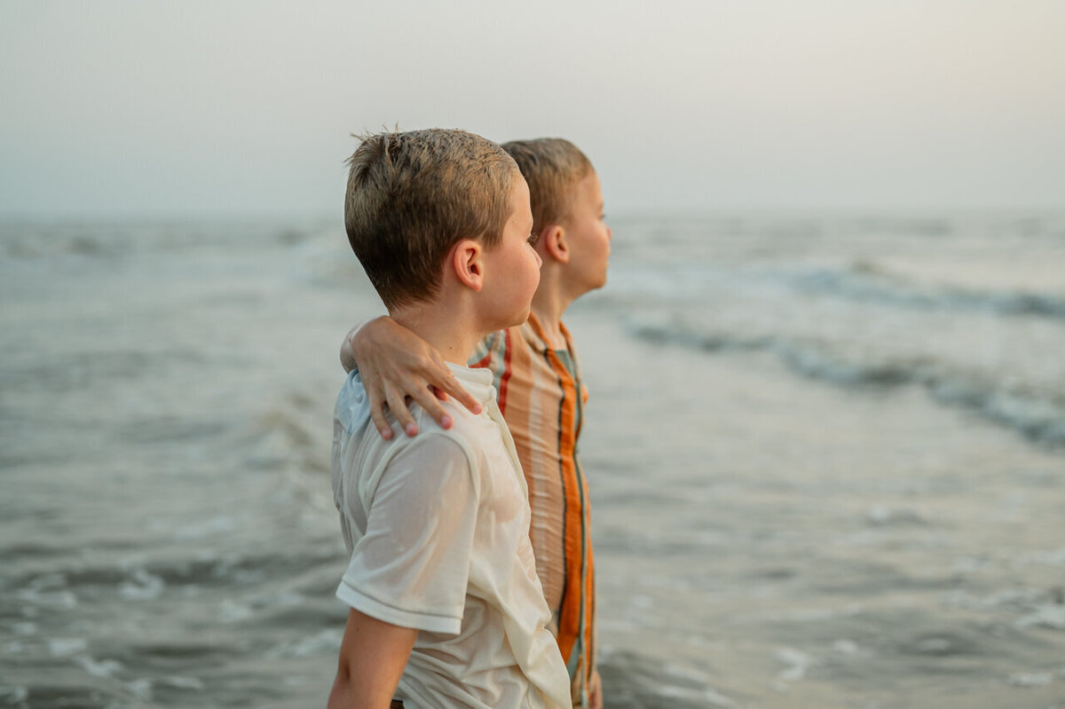 Een professionele fotosessie bij Leiden op het strand van twee broers bij het water.