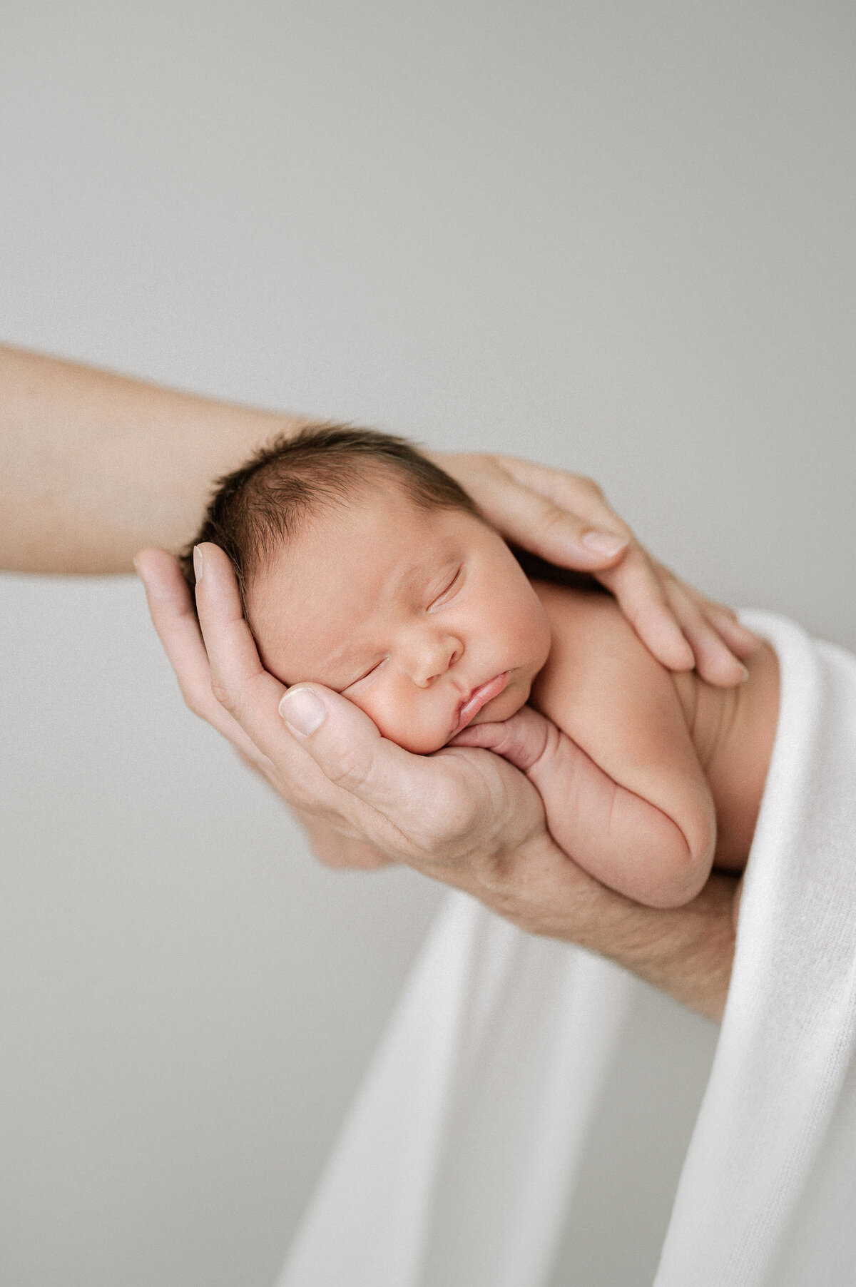 Baby cradled in parent's hands