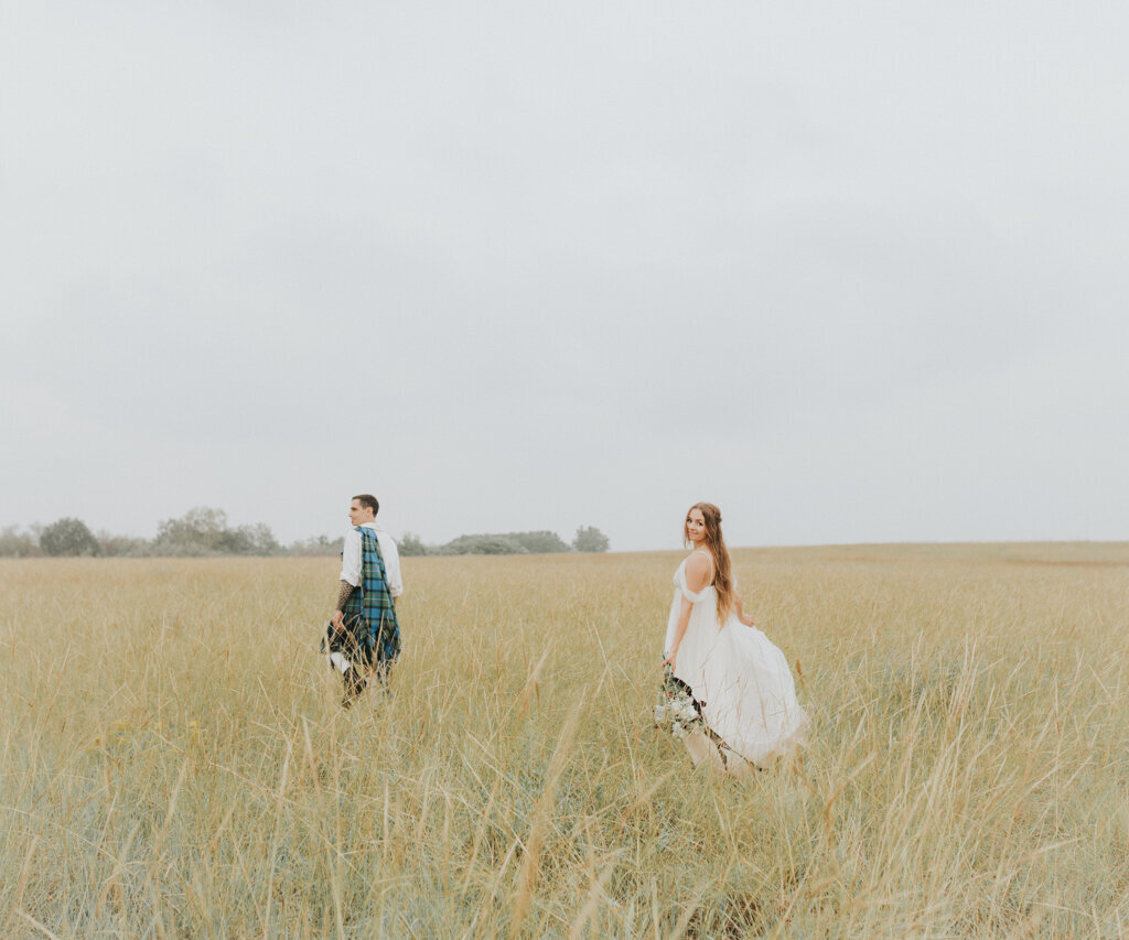 Bride and groom walking through field, captured by Ninth Avenue Studios, authentic and intimate wedding photographer in Calgary, Saskatoon, and Vancouver. Featured on the Bronte Bride Vendor Guide.