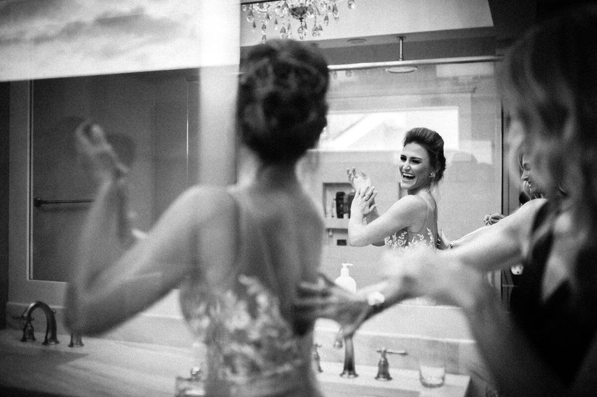 A woman helping a bride adjust her dress.