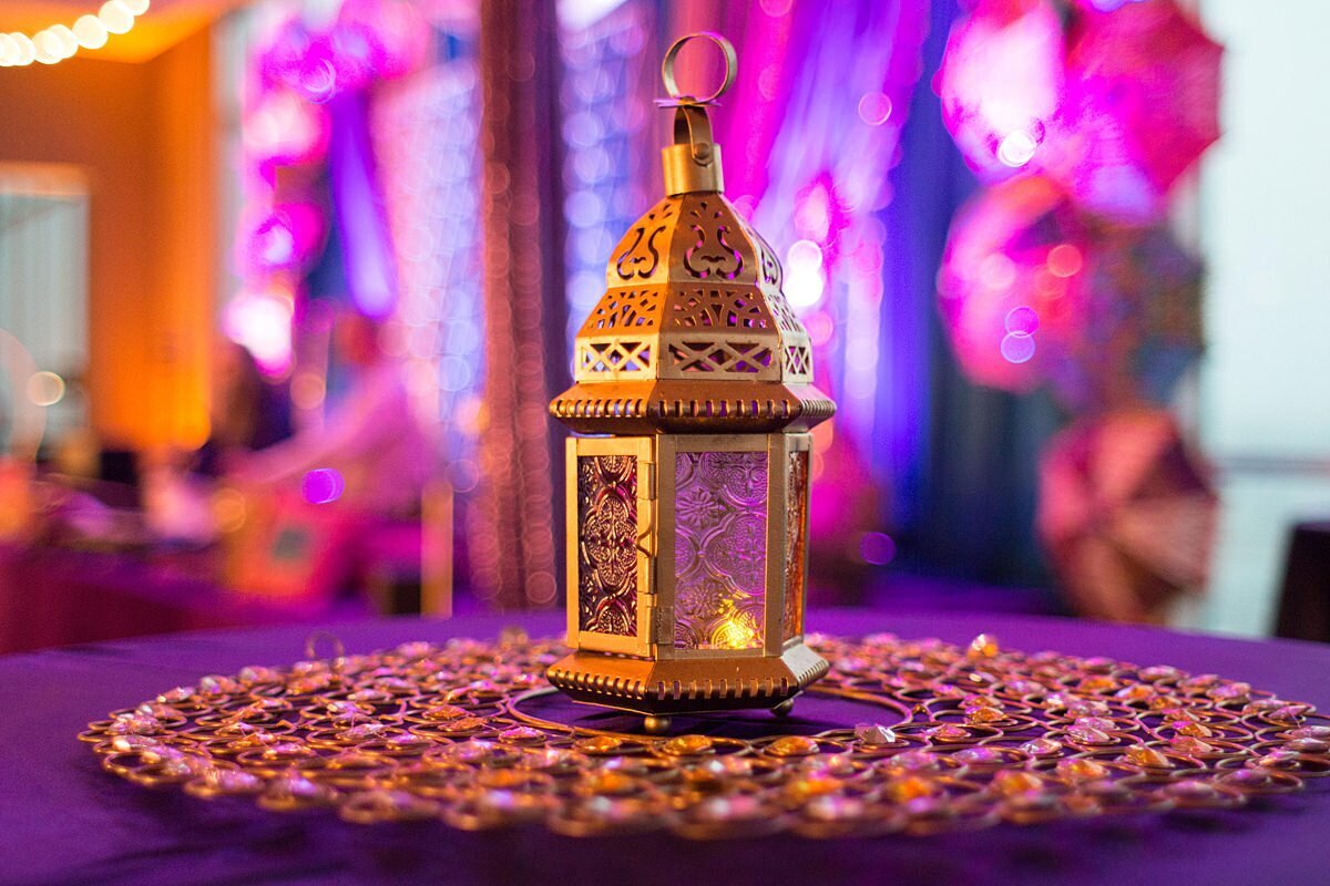 Gold lantern on cocktail table with purple table cloth