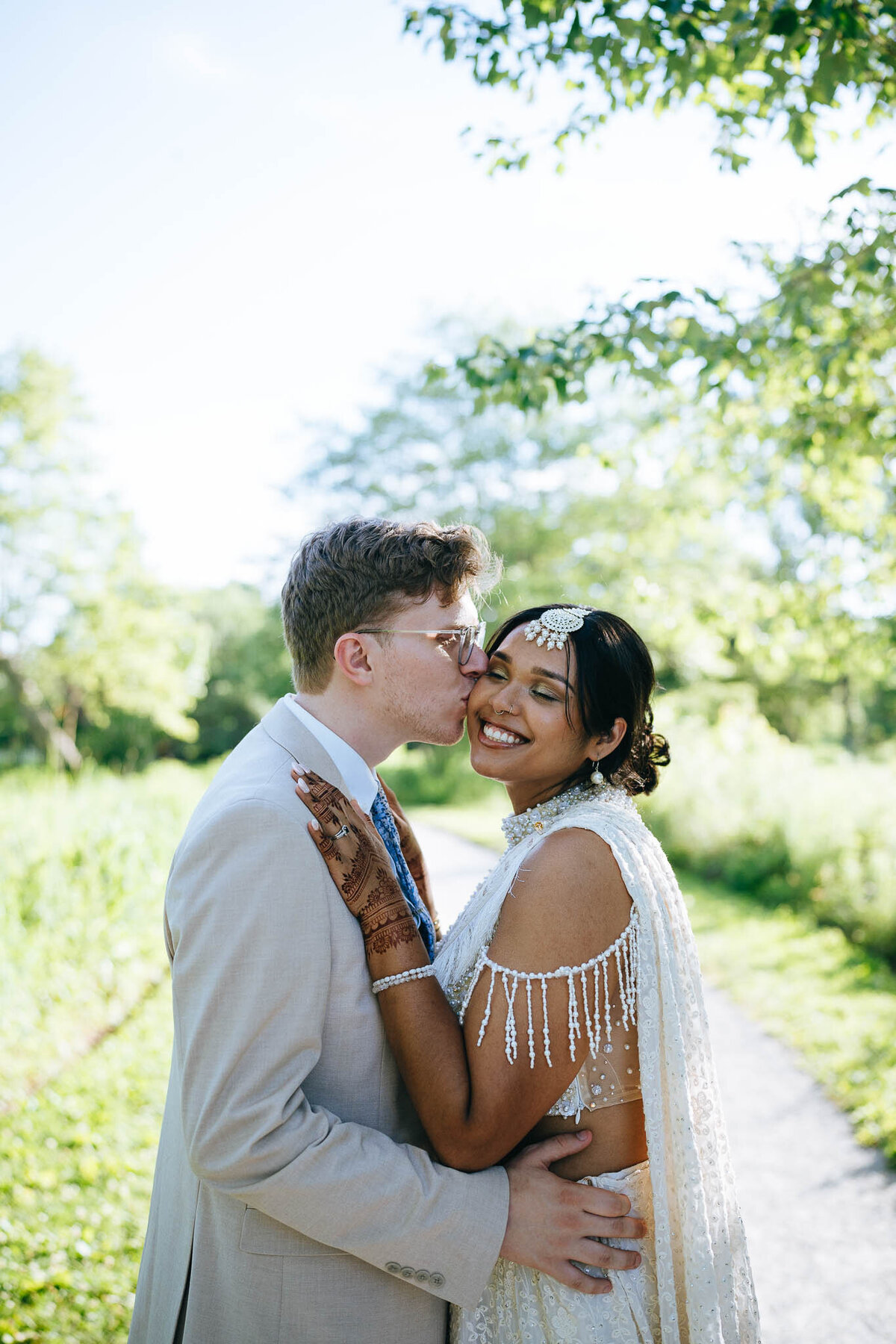 husband kissing wife after ceremony in forest park