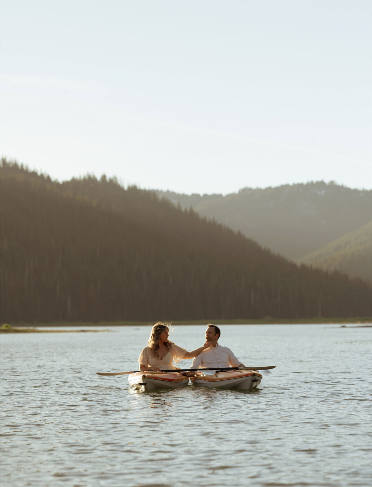 bride and groom share a special moment in their kayaks at Sparks Lake in Bend, OR