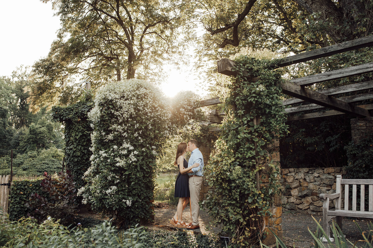 Couple kissing at sunset during engagement photos at Cross Estate Gardens in Bernardsville Somerset County New Jersey
