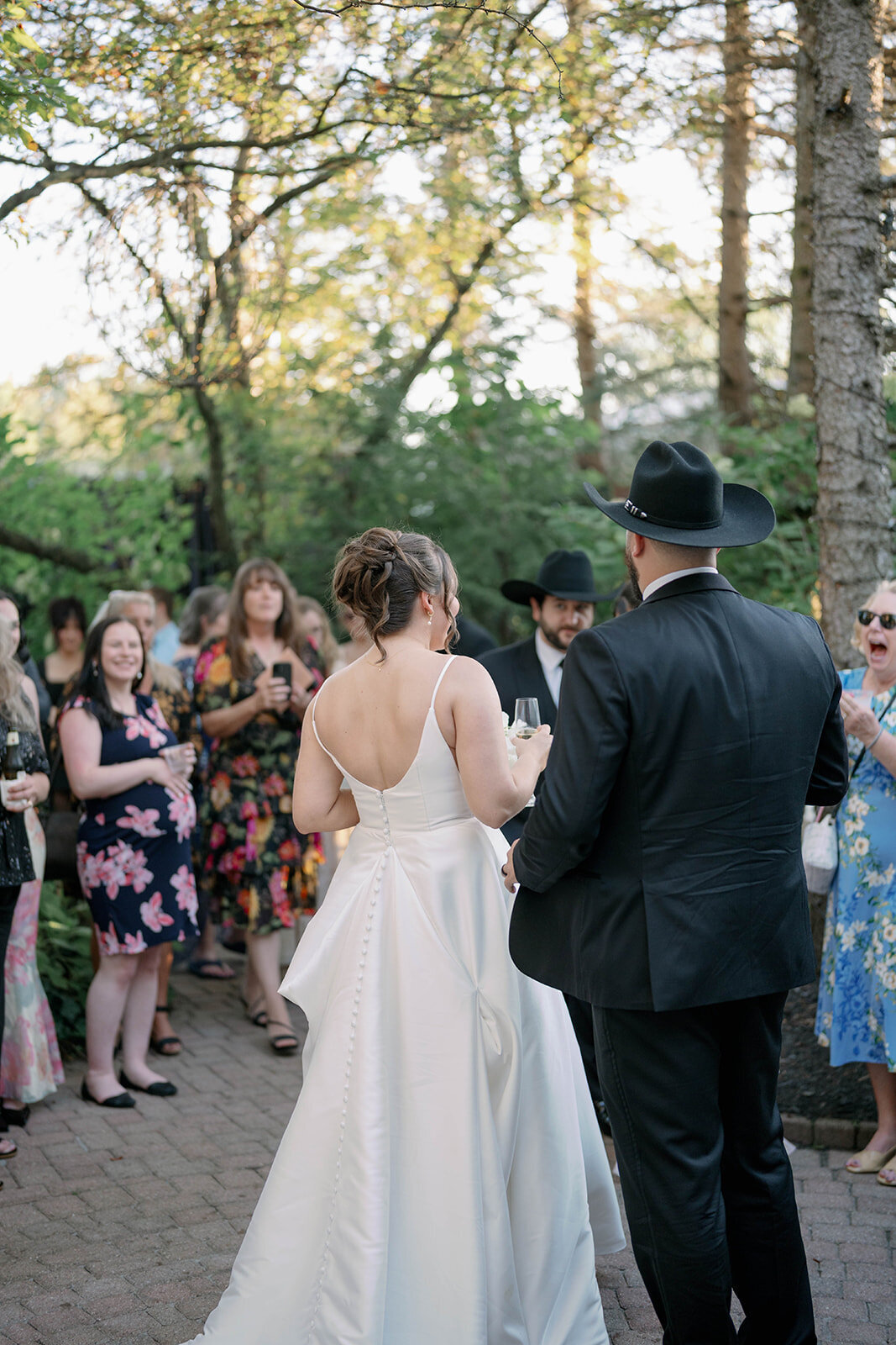 Bride and groom walking up the aisle together after their outdoor Café Cortina ceremony, candid moment with guests.