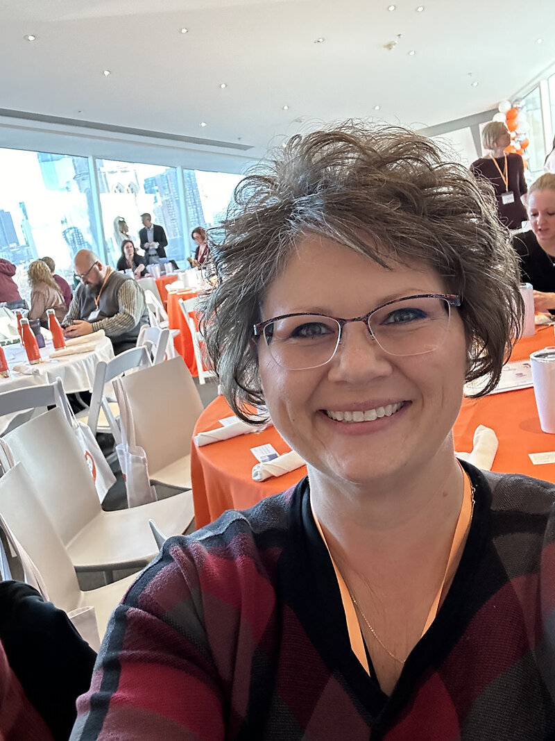 Before photo of client smiling at a professional event, captured indoors with bright lighting before her online dating portrait session with Shannon Kathleen Photography.