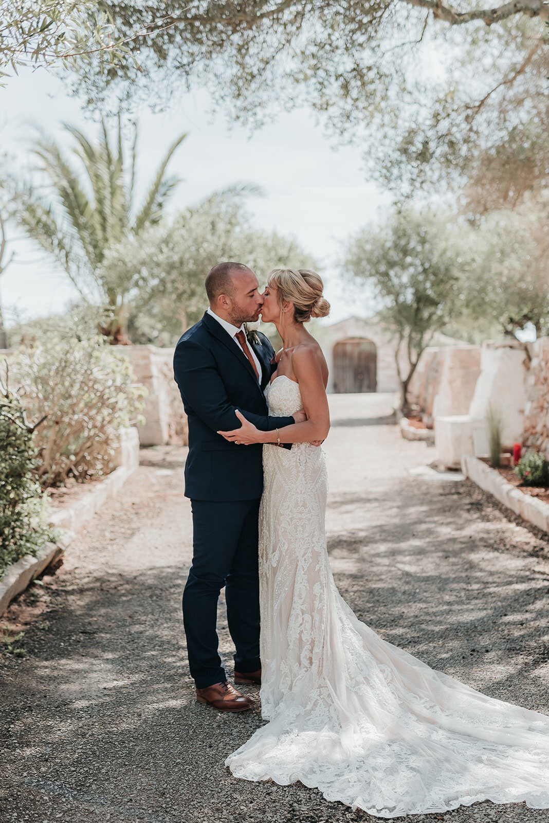 Bride and Groom share a kiss along cobbled pathway during their wedding reception in Sant Lluis Menorca