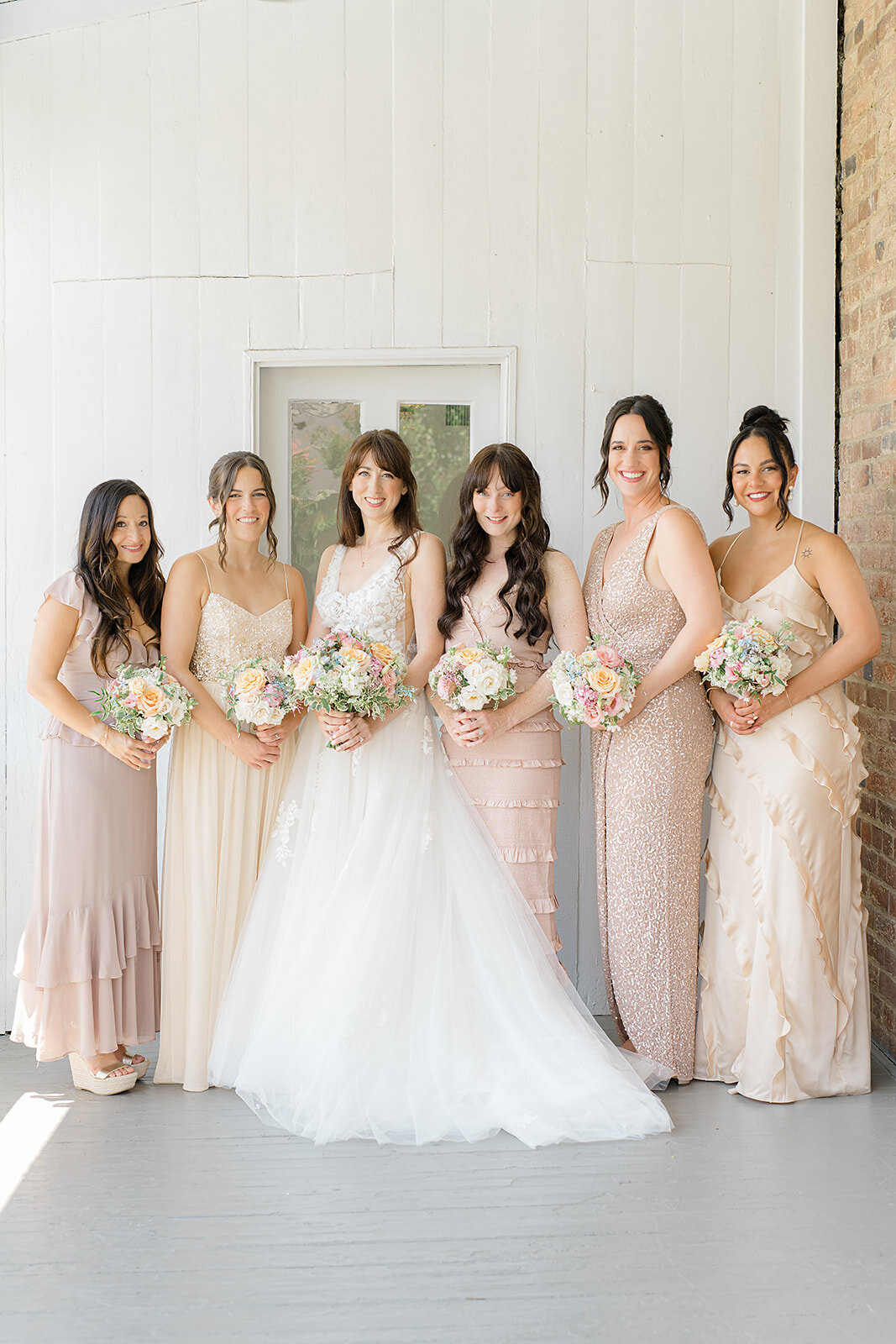 A bride and her five bridesmaids pose for a photo at Birkby House