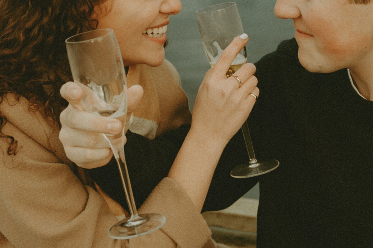 picnic styled engagement session clinking glasses