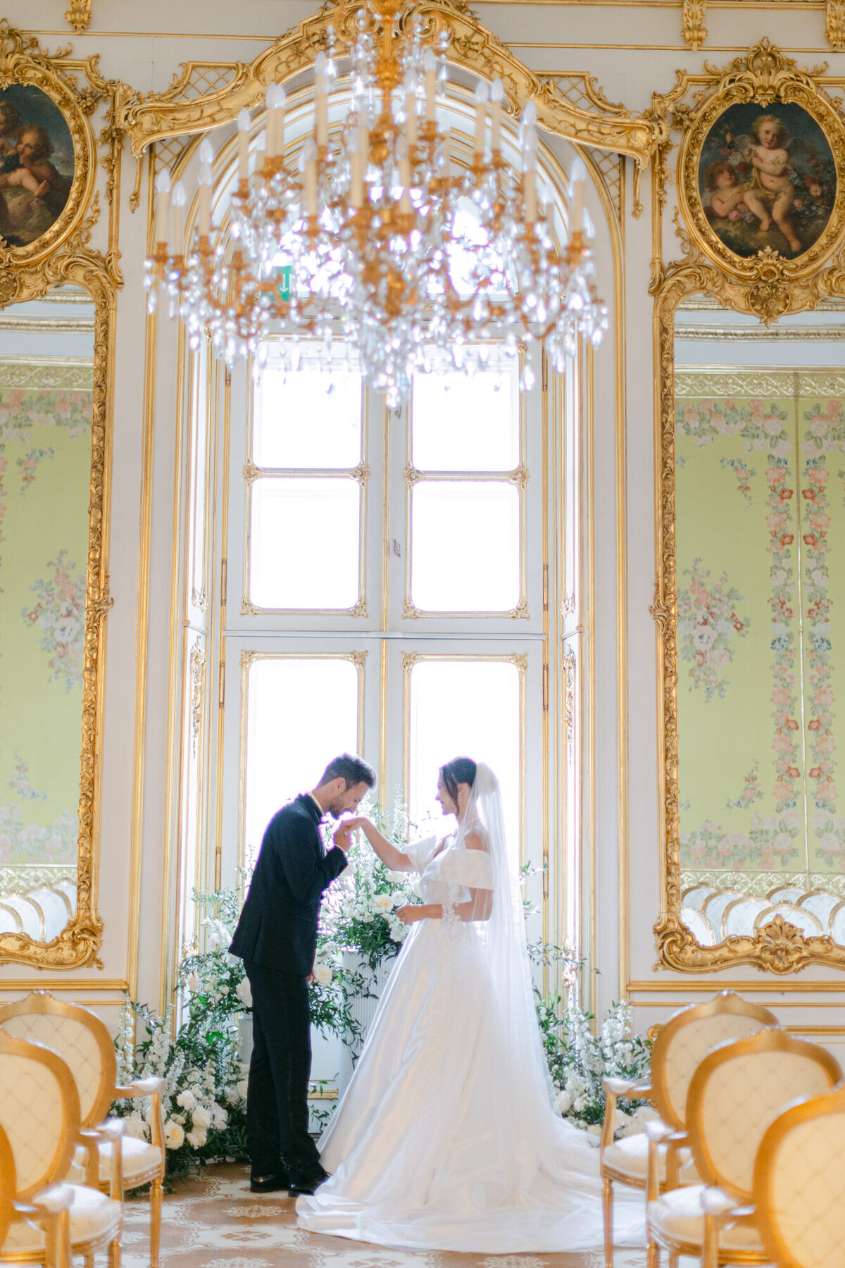 Groom kissing the hand of his bride after the ceremony at the luxury palace Coburg