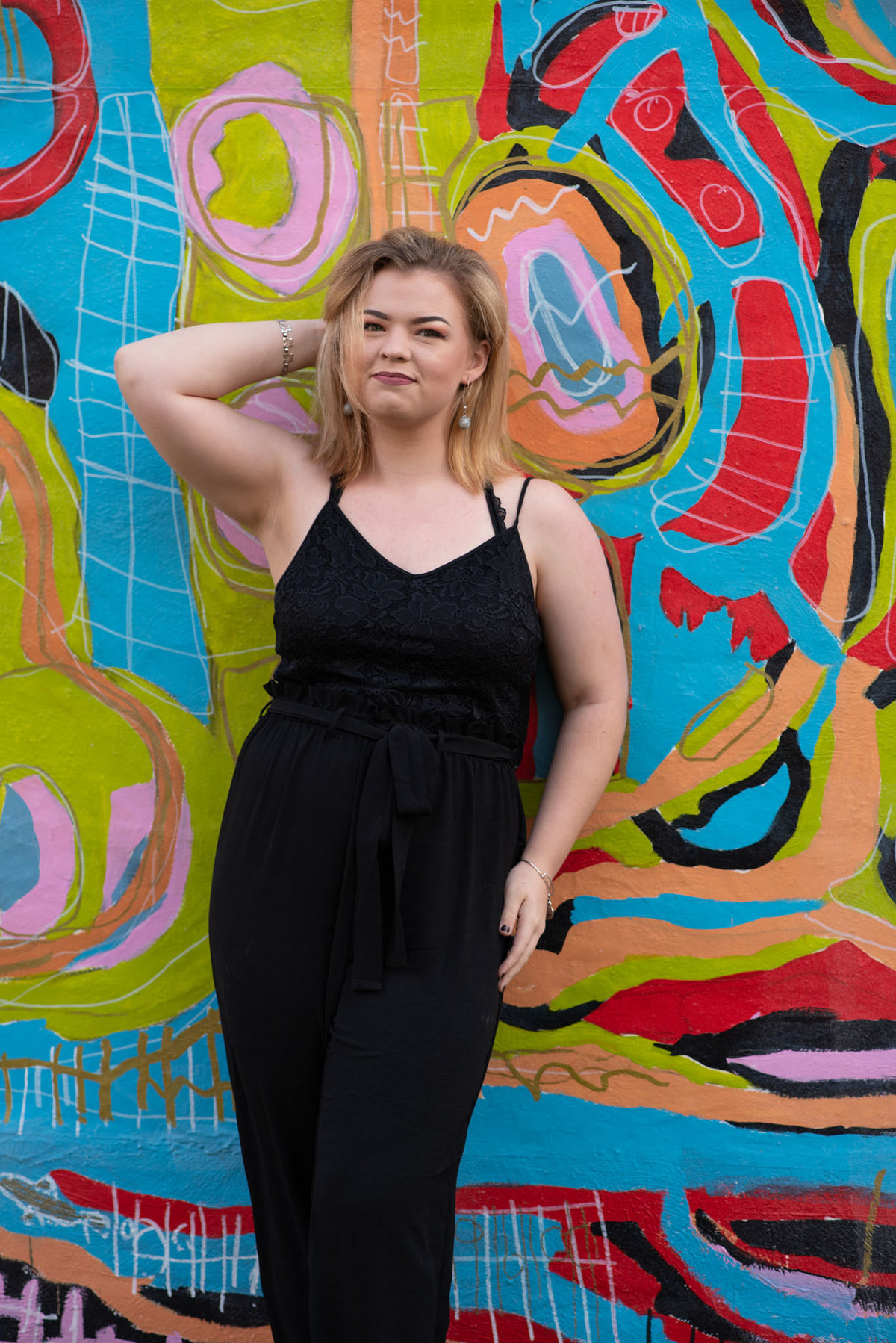 Senior girl posing in front of mural wall