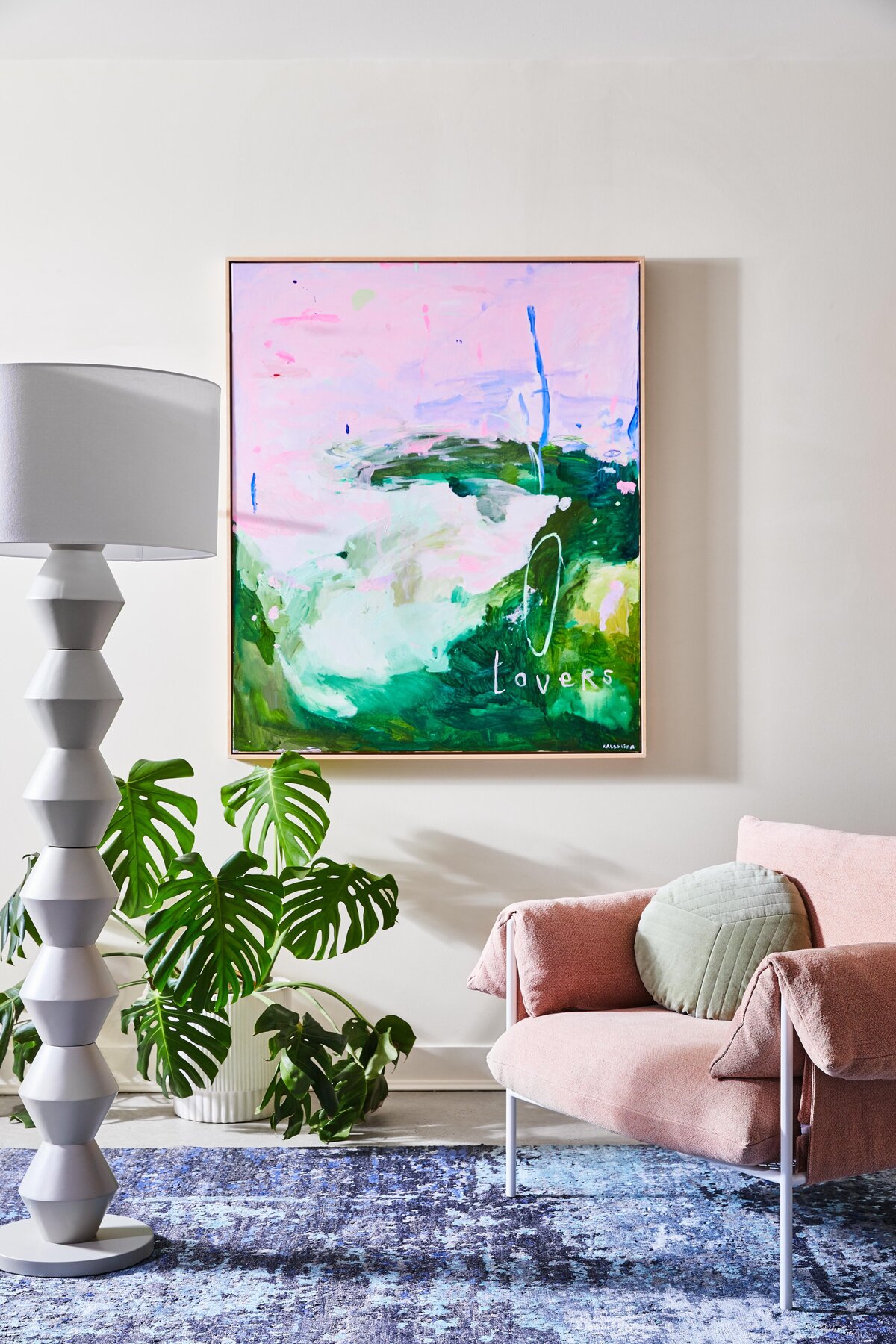 Living room design in Elwood apartment with bold green and pink artwork and pink armchair