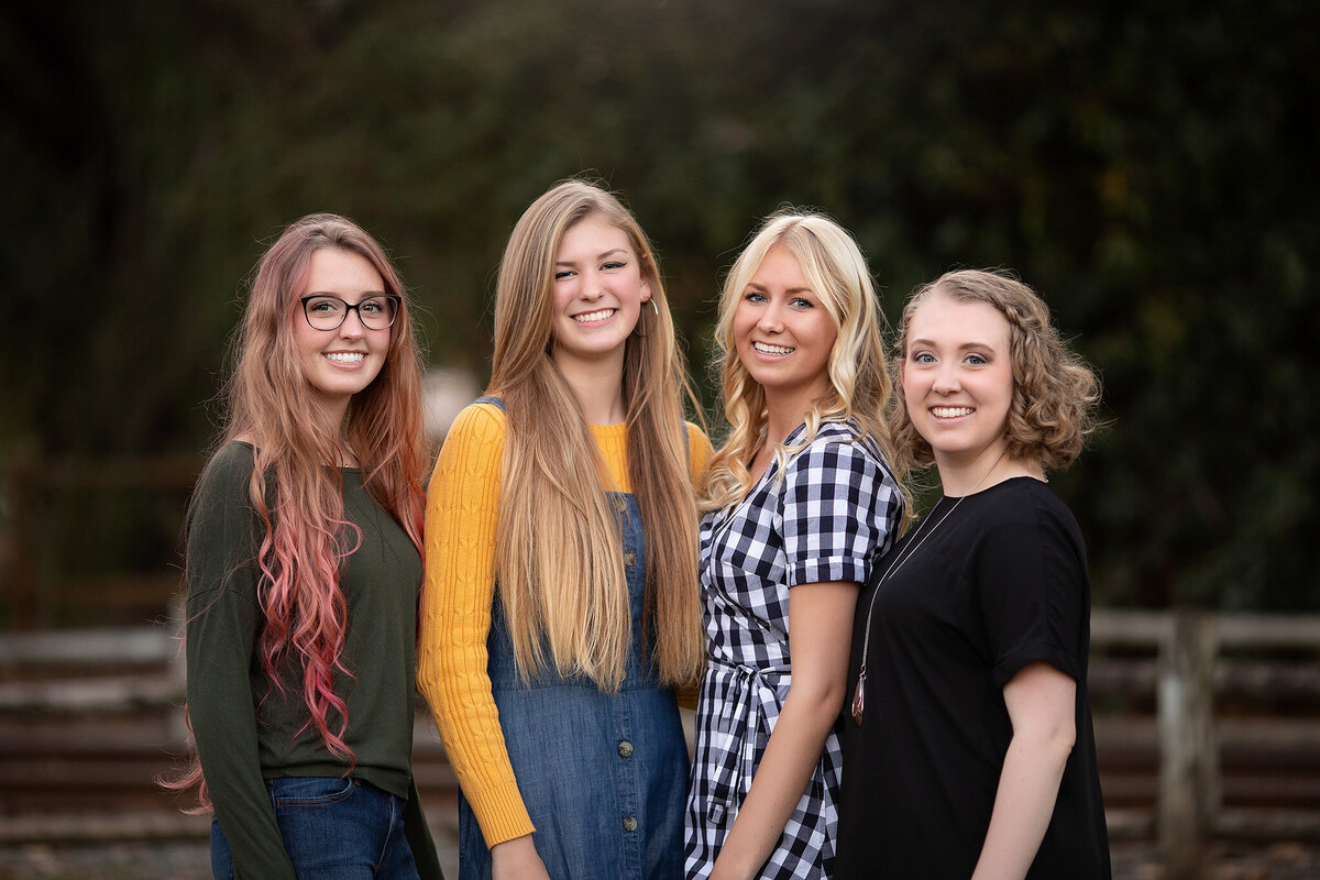 Four young women in a family portrait session, showcasing varying hairstyles and outfits by a Dallas family photographer, capturing the spirit of family photography in Dallas.