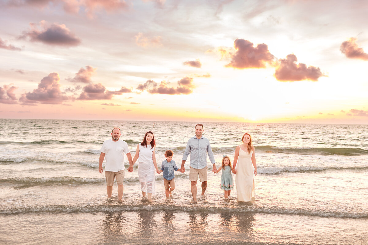 Children running through the sand during a large family session at Indian Rocks Beach.