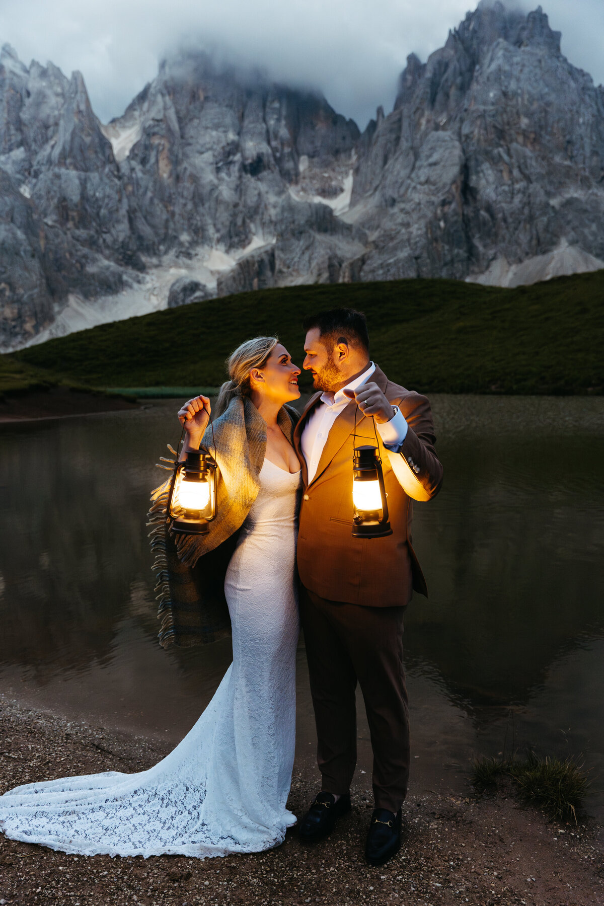 Romantic lantern-lit portrait of couple at mountain lake