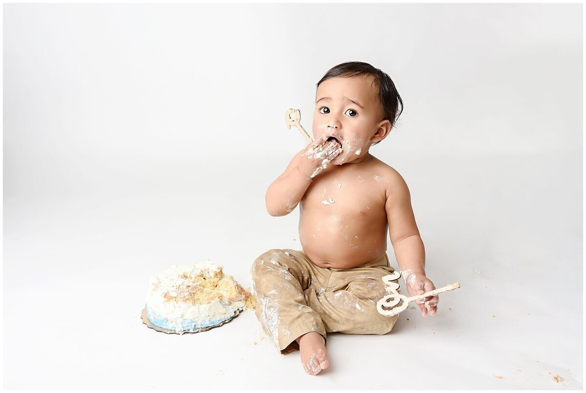 A sweet and messy cake smash session showcasing a child's excitement and curiosity.