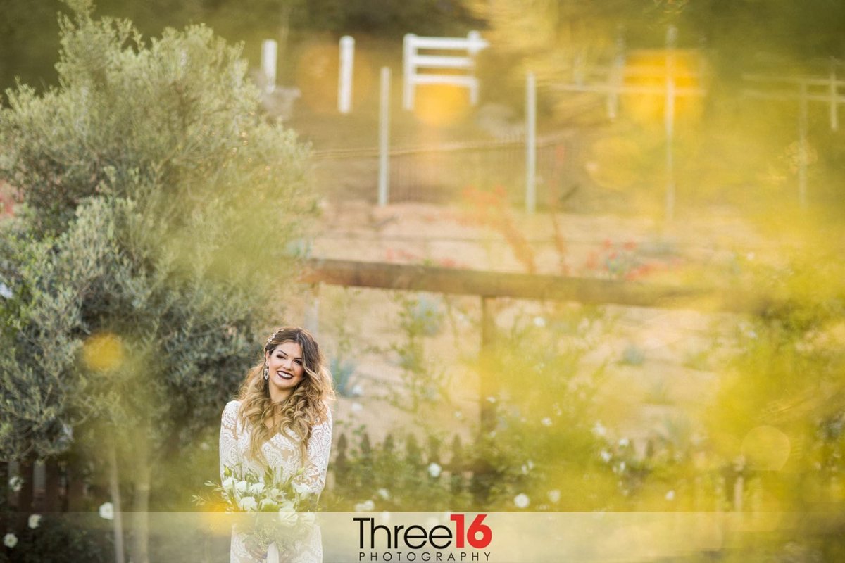 Bride to be posing for photos along the path of flowers