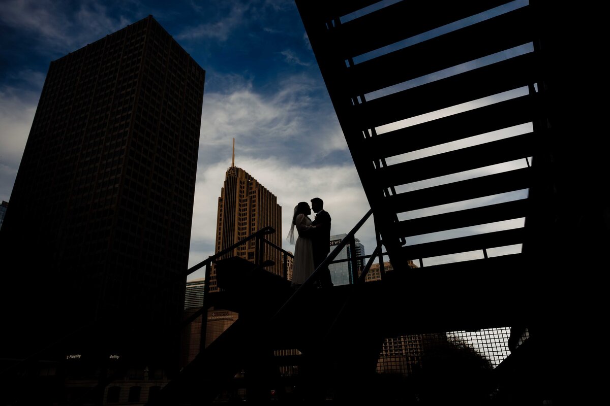 Bride and groom kiss on stairs in CHicago.