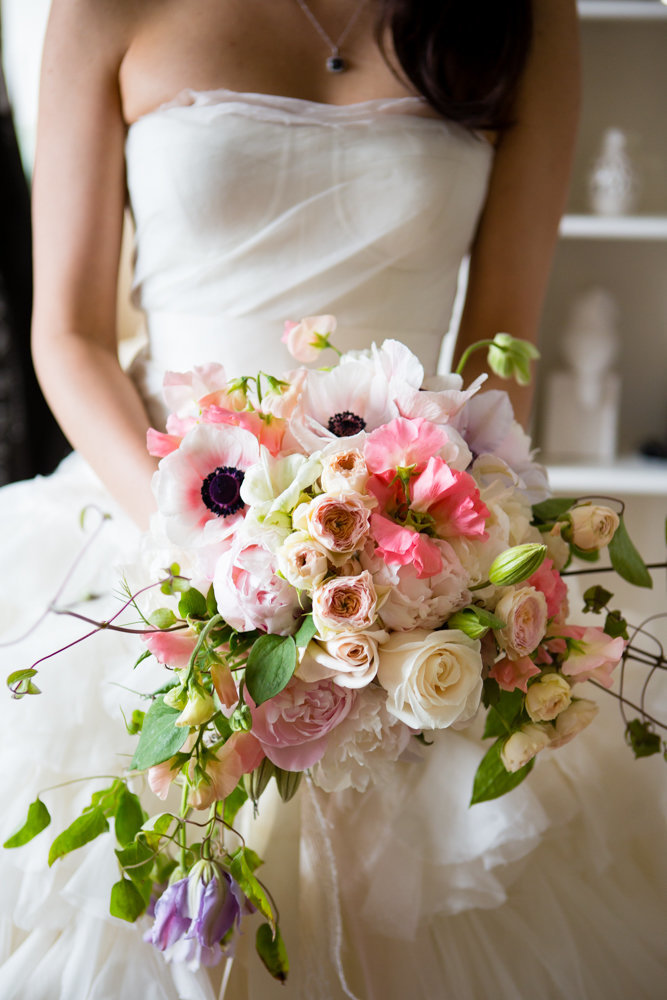 Beautiful spring bridal bouquet of peonies, anemone, and clematis vines.
