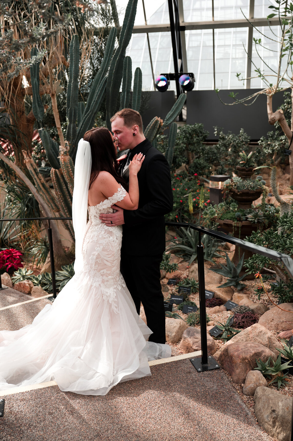 wedding couple kissing in desert greenhouse