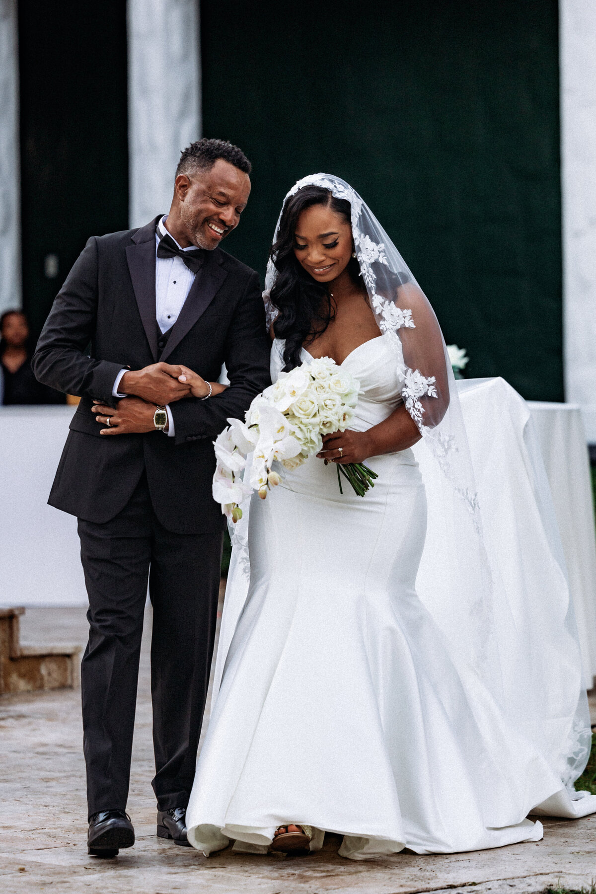 Shannon Lee, from Love Like Wild Photography, captures a joyful moment between a bride and her father as they walk down the aisle.