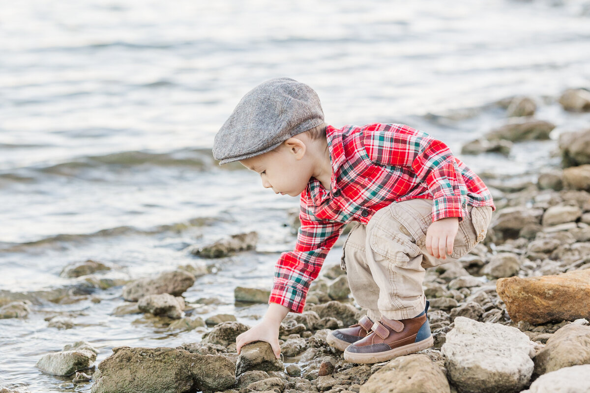 little-boy-by-the-lake-pciking-up-rocks