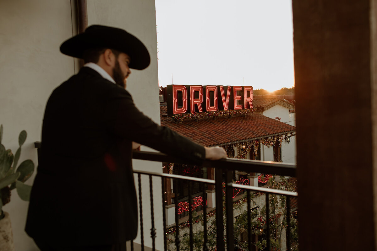 Fort Worth Wedding Photographer Megan Christine Studio captures a sunset moment of a groom in a cowboy hat at Hotel Drover in the Stockyards. 