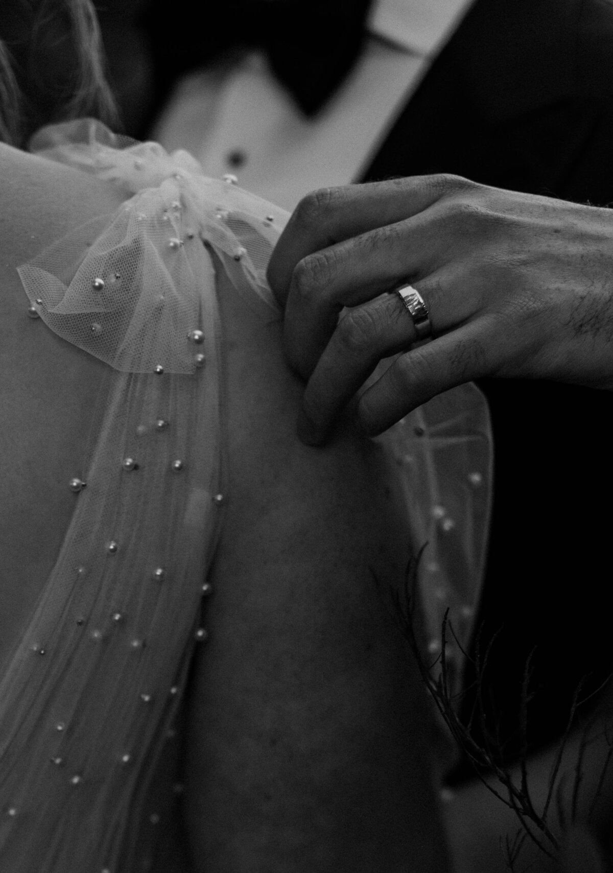 Groom touching bride's shoulder black and white close up