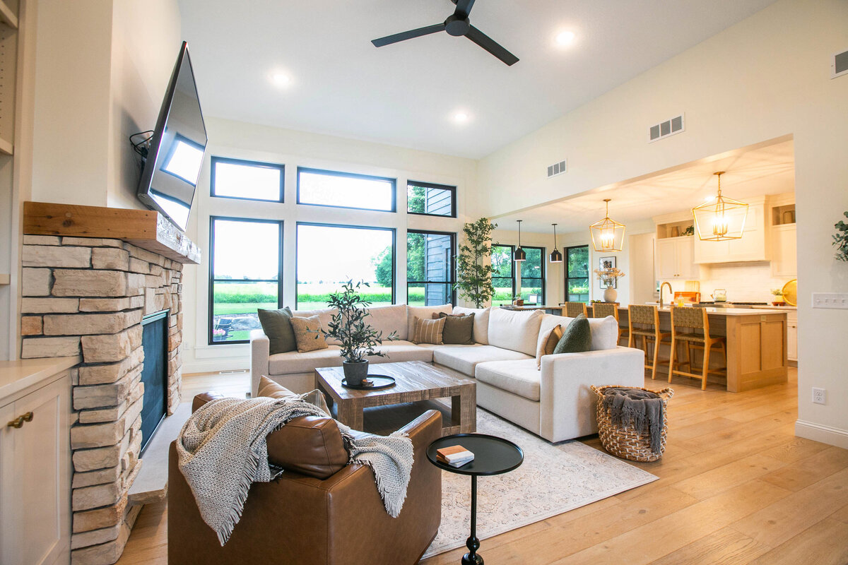 Cozy living room in Otsego custom home with fireplace, built-ins, and large windows